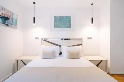 a bed with white sheets and pillows in a room at Magic Home, everything you need. in Funchal