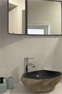 a bathroom with a stone sink and a mirror at Casa da Estrelinha in Carrapateira