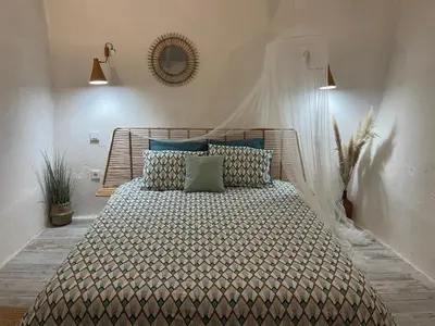 a bedroom with a large bed with blue pillows at Casa da Estrelinha in Carrapateira