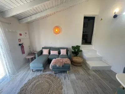 a living room with a blue couch and a staircase at Casa da Estrelinha in Carrapateira