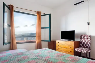 a bedroom with a bed and a tv and a window at Slice of Paradise- Palheiro de Golf in Funchal
