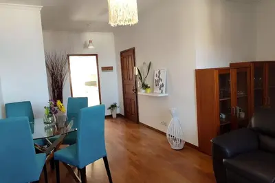 a living room with a table and blue chairs at Jardim Sol Holiday Apartment in Funchal