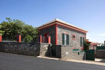 a small brick building on the side of a street at Corman House, Sea View & Pool in Arco da Calheta