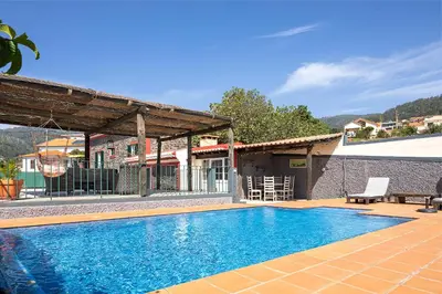 a swimming pool in front of a house at Corman House, Sea View & Pool in Arco da Calheta