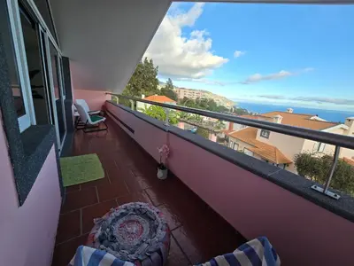 a balcony with a chair and a view of the ocean at Casa dos Amigos Panoramic View in Funchal