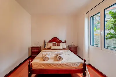 a bedroom with a bed and a large window at Casa Dolce Vita in Ponta do Sol