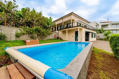 a swimming pool in front of a house at Casa Dolce Vita in Ponta do Sol