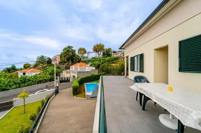 a balcony of a house with a table and chairs at Casa Dolce Vita in Ponta do Sol