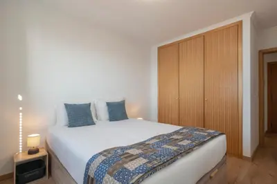 a bedroom with a large bed and a wooden cabinet at Garajau VI by An Island Apart in Santa Cruz