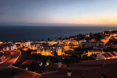 a view of a city at night with the ocean at Garajau VI by An Island Apart in Santa Cruz
