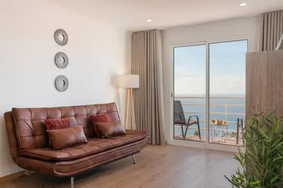 a living room with a couch and a view of the ocean at Garajau VI by An Island Apart in Santa Cruz