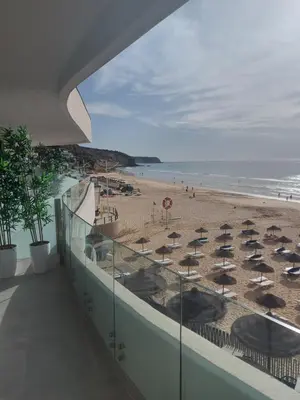 a view of a beach from a building with umbrellas at Villamar in Salema
