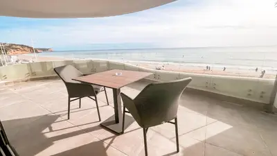 a table and chairs with a view of the beach at Villamar in Salema