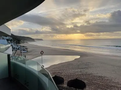 a view of the beach at sunset with the ocean at Villamar in Salema
