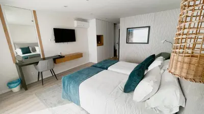 a bedroom with a large white bed and a desk at Villamar in Salema