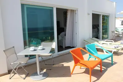 a patio with chairs and a table and a table and chairs at Breathtaking Villa with infinity pool over the sea in Luz
