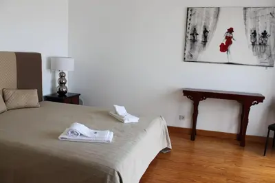 a bedroom with a bed and a table with a picture on the wall at Breathtaking Villa with infinity pool over the sea in Luz