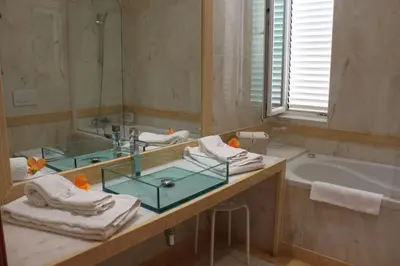 a bathroom with a tub and a sink and a mirror at Breathtaking Villa with infinity pool over the sea in Luz