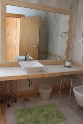 a bathroom with a sink and a mirror and a toilet at Breathtaking Villa with infinity pool over the sea in Luz
