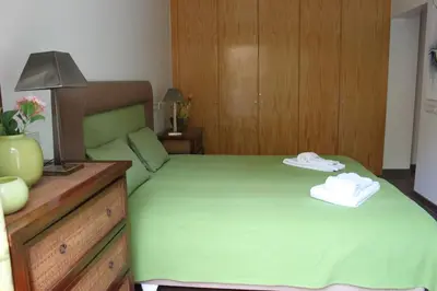 a bedroom with a green bed with two towels on it at Breathtaking Villa with infinity pool over the sea in Luz