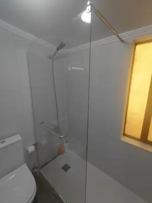 a bathroom with a glass shower with a toilet at Cayenne House in Santa Cruz