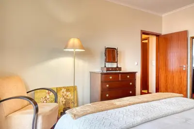 a bedroom with a bed and a dresser and a tv at Lidia's Place, a Home in Madeira in Ponta do Sol