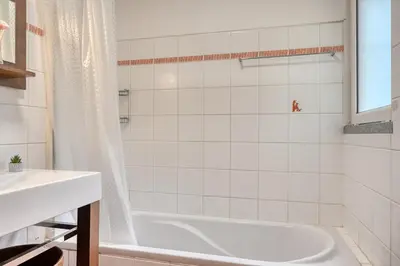 a white bathroom with a tub and a sink at Lidia's Place, a Home in Madeira in Ponta do Sol