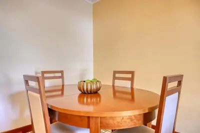 a wooden table with chairs and a bowl of fruit on it at Lidia's Place, a Home in Madeira in Ponta do Sol
