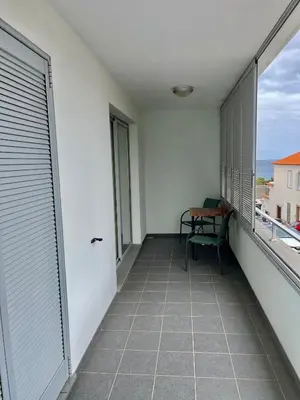 a balcony with a chair and a view of the ocean at Apartamento da vila, Porto Santo. in Vila Baleira