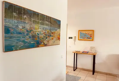 a painting hanging on a wall next to a table at Apartamento da vila, Porto Santo. in Vila Baleira
