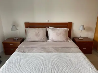 a bedroom with a large bed with two night stands at Apartamento da vila, Porto Santo. in Vila Baleira