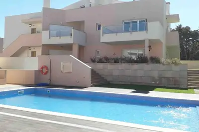 a house with a swimming pool in front of a house at Burgau 2floor appt in condominium w/ shared pool in Burgau