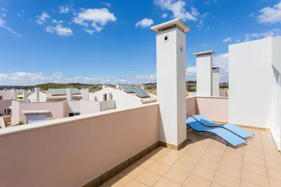 a balcony with a blue chair on a roof at Burgau 2floor appt in condominium w/ shared pool in Burgau