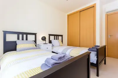 a bedroom with two beds with towels on them at Burgau 2floor appt in condominium w/ shared pool in Burgau