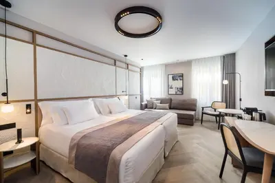 a bedroom with a large bed and a living room at Barceló Funchal Oldtown in Funchal