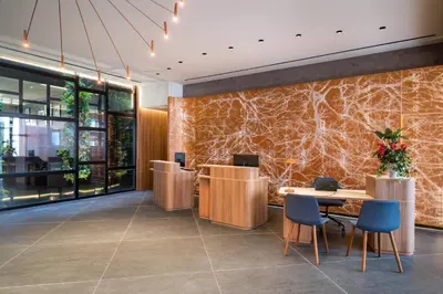 a lobby with tables and chairs and a stone wall at Barceló Funchal Oldtown in Funchal
