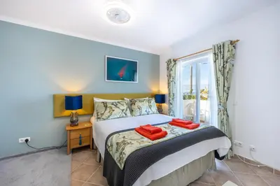 a bedroom with a bed with two red towels on it at Casa Da Bauhinia in Aljezur