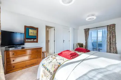 a bedroom with a bed and a flat screen tv at Casa Da Bauhinia in Aljezur