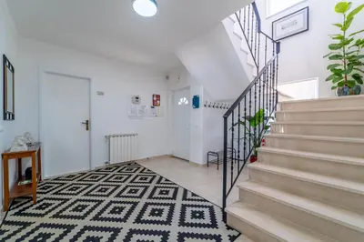 a white hallway with stairs and a rug at Casa Da Bauhinia in Aljezur