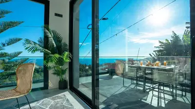 a balcony with a table and chairs and a view of the ocean at Casa Erbozeta by LovelyStay in Funchal