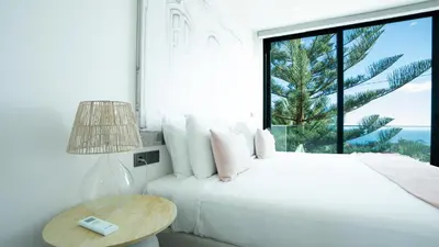 a bedroom with a white bed and a large window at Casa Erbozeta by LovelyStay in Funchal