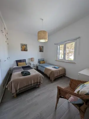 a white room with two beds and a window at Casa Oliveira in Sagres