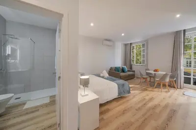 a bedroom with a bed and a bathroom at Art Deco Central Apartments, Funchal in Funchal