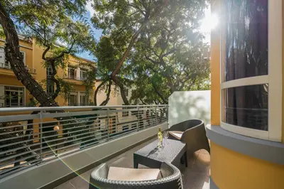 a balcony with a table and chairs and trees at Art Deco Central Apartments, Funchal in Funchal