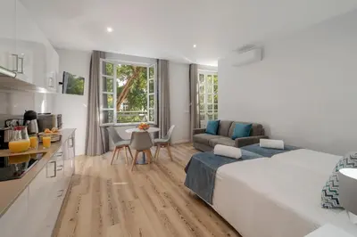 a bedroom with a bed and a kitchen and a living room at Art Deco Central Apartments, Funchal in Funchal