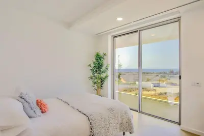 a bedroom with a bed and a large window at Ocean view Architectural Modern Villa in Burgau