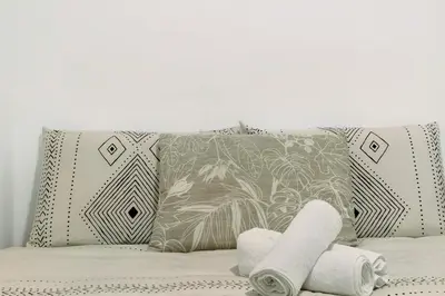 a bed with two pillows and two towels on it at Funchal House in Funchal