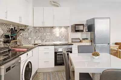 a kitchen with white cabinets and a white table at Funchal House in Funchal