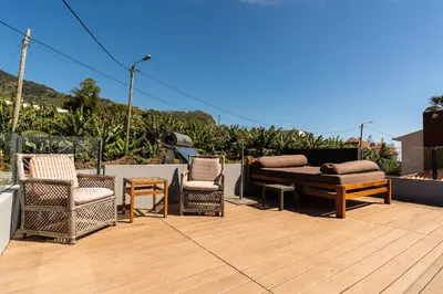 a group of chairs and a couch on a patio at Calheta Tangerine House in Arco da Calheta