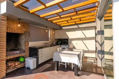 a kitchen with a table and a kitchen with a table at Calheta Tangerine House in Arco da Calheta